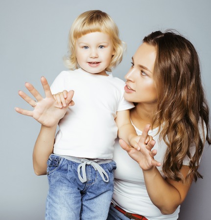 pretty real fashion mother with cute blond little daughter close up smiling happy wearing white shirtの写真素材