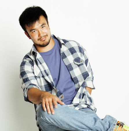 young cute asian man on white background gesturing emotional, pointing, smiling, lifestyle real...