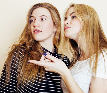 lifestyle and people concept: Fashion portrait of two stylish sexy girls best friends, over white background. Happy time for fun. fooling around smilingの写真素材