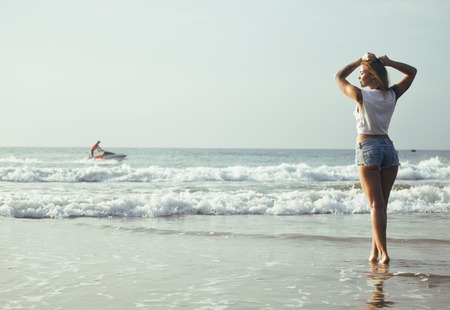 young pretty blond woman at seacoast walking relaxing, fashion lady sunset, people on summer...