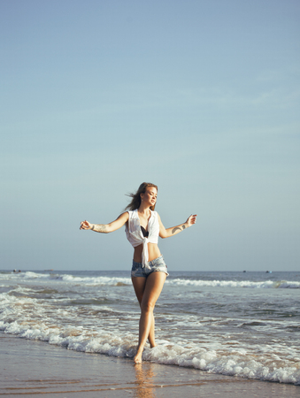 real blonde girl along on seacost walking, healthy at sunrise, lifestyle people conceptの写真素材