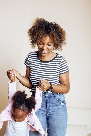 adorable sweet young afro-american mother with cute little daughter, hanging at home, having fun...
