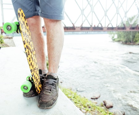 young handsome real hipsrter guy bearded staying under the bridge extreeme with leopard skateboard,...