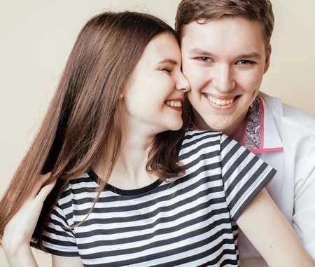 couple of happy smiling teenagers students in love, warm colors having a kiss, lifestyle people conceptの写真素材
