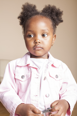 little cute sweet african-american girl playing happy with toys at home, lifestyle children concept close upの写真素材
