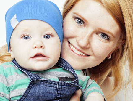 young beauty mother with cute baby, red head happy modern family isolated on white background close up, lifestyle real people conceptの写真素材