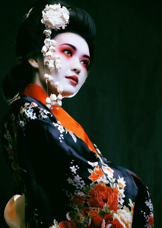 Young beautiful asian woman's portrait, geisha in kimono on blackの写真素材