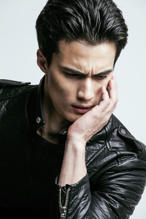 young handsome man, leather jacked on naked torso, emotional posing, white background, modern guy,...