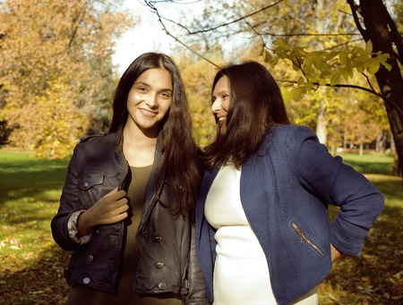 mature real mother with daughter outside autumn fall in park, recreation conceptの写真素材