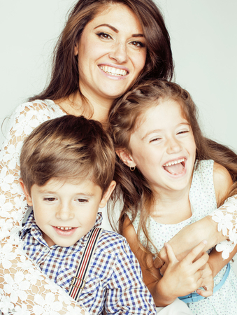 young mother with two children on white background, happy smiling family inside isolated close upの写真素材
