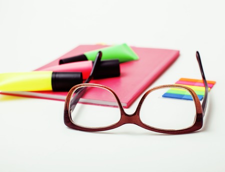 business, education and technology concept - close up of notebook, paper stickers, pencil different real stuff on white backgroundの写真素材