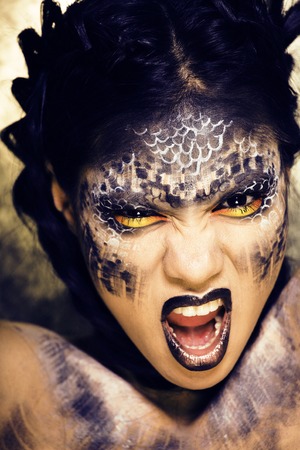 fashion portrait of pretty young woman with creative make up like a snake, halloween look close upの写真素材