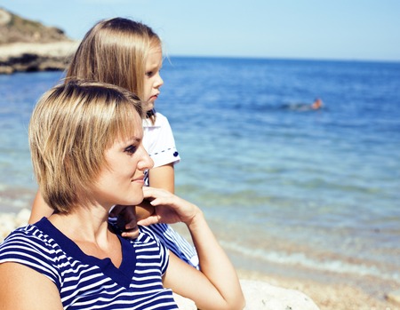mother with daughter at sea cost together, happy real family smiling looking to horizont, lifestyle people concept, on vacations close upの写真素材