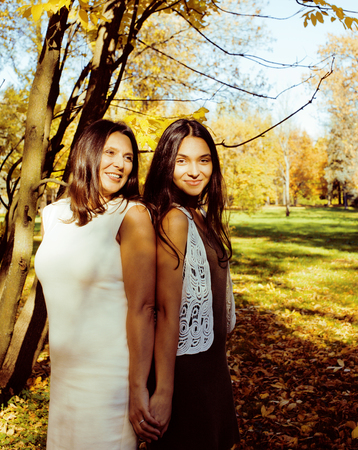 mature real mother with teenage daughter outside autumn fall in park, lifestyle happy smiling people concept close upの写真素材