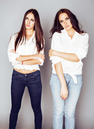 two sisters twins posing, making photo selfie, dressed same white shirt, diverse hairstyle friends, lifestyle people conceptの写真素材