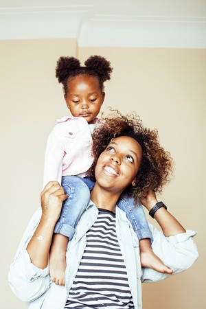 adorable sweet young afro-american mother with cute little daughter, hanging at home, having fun playing smiling, lifestyle people concept, happy smiling modern family close upの写真素材