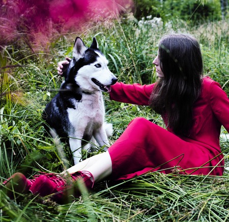 Mysterious woman in red dress with tree wolfs, forest, husky dogs mystery portrait