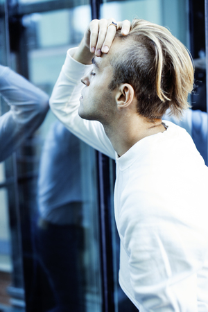 young modern hipster guy at new building university blond fashion hairstyle having fun, lifestyle people concept close upの写真素材