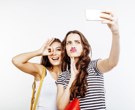 two best friends teenage girls together having fun, posing emotional on white background, besties happy smiling, making selfie, lifestyle people concept close upの写真素材