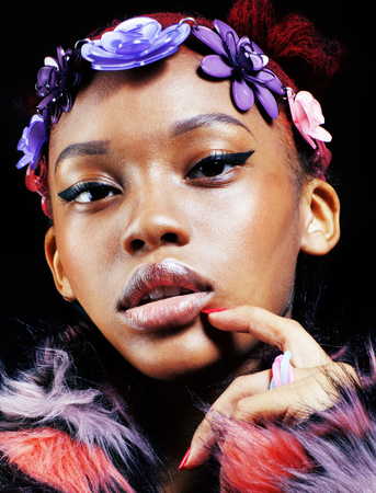 young pretty african american woman in spotted fur coat and flowers jewelry on head smiling sweet...