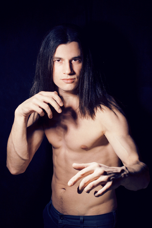 handsome young man with long hair naked torso on black background smiling, lifestyle people concept close upの写真素材