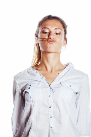 cute young pretty girl thinking on white background isolated close up smiling, messing with hair, gesturingの写真素材