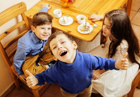 little cute boys eating dessert on wooden kitchen. home interior. smiling adorable friendship together forever friends, lifestyle people concept close upの写真素材