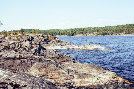 wild north nature landscape. lot of rocks on lake shore post card view
