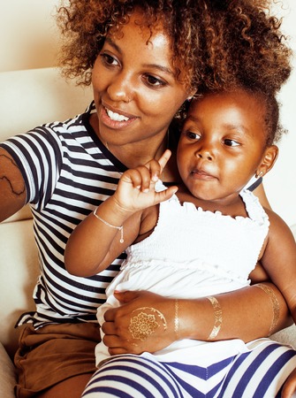 adorable sweet young afro-american mother with cute little daughter, hanging at home, having fun playing smiling, lifestyle people concept close upの写真素材