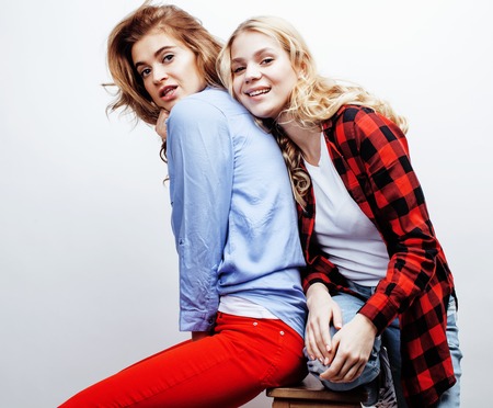 two pretty blond woman having fun together on white background, mature mother and young teenage daughter, lifestyle people concept close upの写真素材