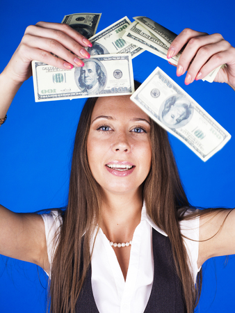 pretty young brunette real modern woman with money cash on blue background happy smiling, lifestyle people conceptの写真素材