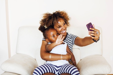 adorable sweet young afro-american mother with cute little daughの写真素材