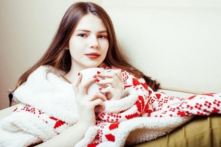 young pretty brunette girl in Christmas ornament blanket getting warm on cold winter, freshness beauty concept, lifestyle peopleの写真素材