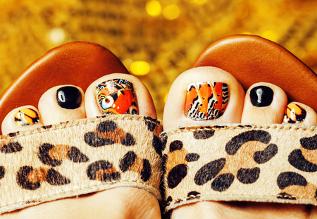 photo of pedicure like butterfly design on gold background close up, mani pedi creative conceptの写真素材
