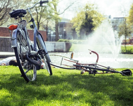 lifestyle people concept: couple of bicycle on green grass in summer park at fountainの写真素材