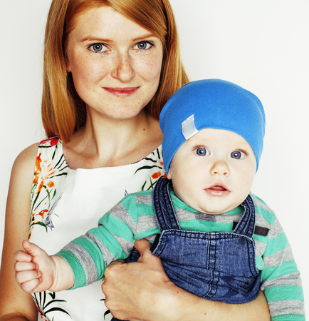 young beauty mother with cute baby, red head happy modern familyの写真素材