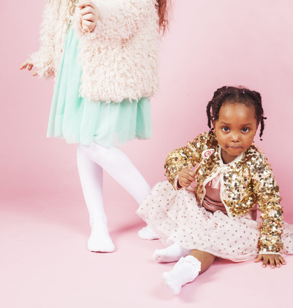 lifestyle people concept: diverse nation children playing together, caucasian boy with african little girl holding candy happy smilingの写真素材