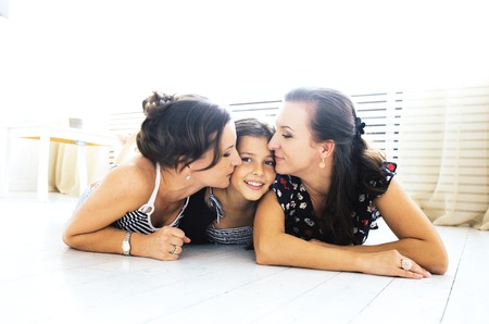 Mature sisters twins at home with little daughter, happy familyの写真素材
