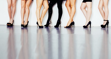 diverse type pair of woman legs in hight heels black shoes isolated on white background and floor, diversity people lifestyle conceptの写真素材