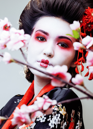 young pretty geisha in black kimono among sakura, asian ethno close upの写真素材