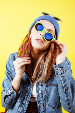 young pretty long hair teenage hipster girl posing emotional happy smiling on yellow background, lifestyle people conceptの写真素材