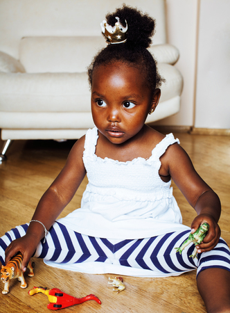 little cute african american girl playing with animal toys at hoの写真素材