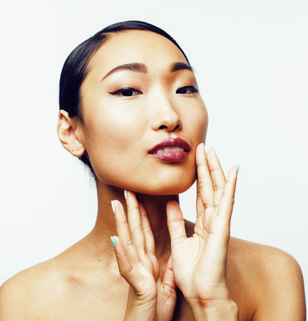 young pretty asian woman with hands on face isolated on white background, stylish fashion healthcare people conceptの写真素材