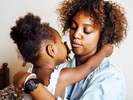 adorable sweet young afro-american mother with cute little daughの写真素材