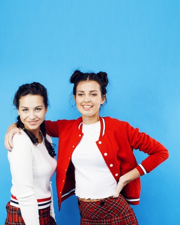 best friends teenage school girls together having fun, posing emotional on blue background, besties happy smiling, lifestyle people conceptの写真素材