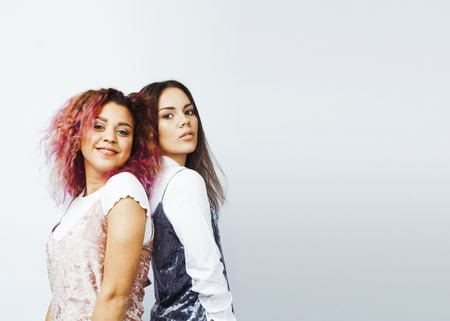 lifestyle people concept: two pretty stylish modern hipster teen girl having fun together, diverse nation mixed races, happy smiling making selfieの写真素材