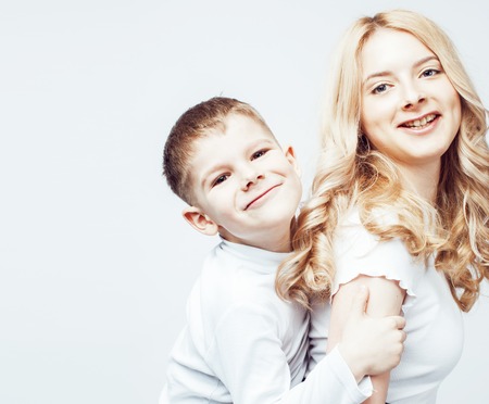 young modern blond curly mother with cute son together happy smiling family posing cheerful on white background, lifestyle people concept, sister and brother friendsの写真素材