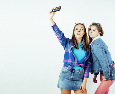 best friends teenage girls together having fun, posing emotional on white background, besties happy smiling, lifestyle people concept close up. making selfieの写真素材