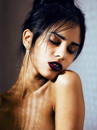 pretty brunette woman with make up like demon at halloween, dark scary look for holiday celebrationの写真素材