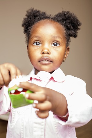 little cute african american girl playing with animal toys at home, pretty adorable princess in interior happy smiling, lifestyle people conceptの写真素材